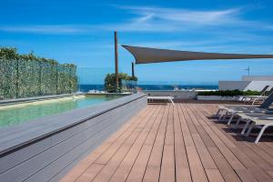 un patio con piscina, mesa y sombrilla en Apartaments B-Llobet Sun & Confort en Ibiza