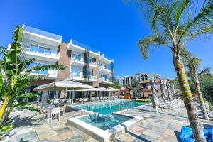 a hotel with a swimming pool and palm trees at Orik Hotel & Spa in Vlorë