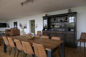 una sala da pranzo con tavolo e sedie in legno di GT Lounge a Heusden-Zolder