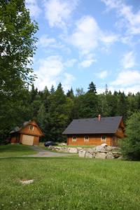 un paio di cabine in legno in un campo alberato di Chalupa Pod Lomem a Dolní Morava