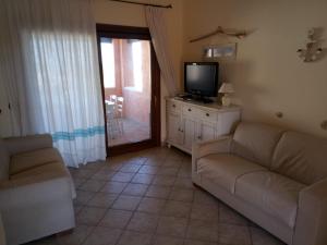 a living room with a couch and a television at Fiordaliso Aurora in Olbia