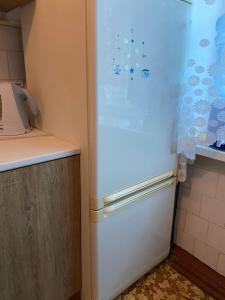 a white refrigerator in a kitchen next to a counter at В Самом центре in Myrhorod