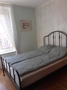 1 cama en un dormitorio blanco con ventana en KWATERA en Gdansk