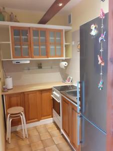 a kitchen with wooden cabinets and a stainless steel refrigerator at KWATERA in Gdańsk