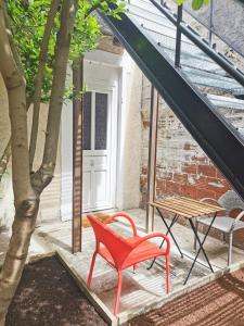 una sedia rossa e un tavolo su un patio di Studio à proximité de Paris a Bagnolet