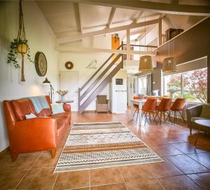 a living room with orange furniture and a dining room at Vakantiewoning Cha Nostra in Moorveld