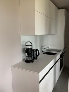 una cocina con armarios blancos y tetera en una encimera. en Seeblick Appartement Henle, en Lochau