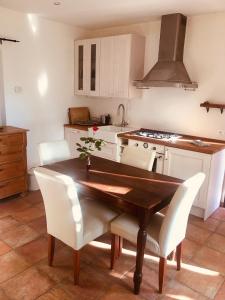 波爾托瓦爾特拉瓦利亞的住宿－Appartamento Ibisco，厨房配有木桌和白色椅子