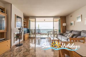 a living room with a couch and a view of the ocean at Apartament R104 in Calafell
