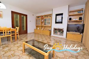 sala de estar con TV y mesa en Apartament R104, en Calafell