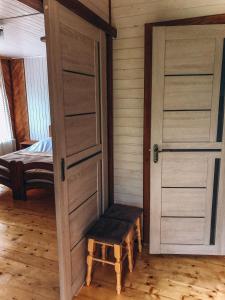 a room with doors and a stool and a bed at Апартаменти у Верховині in Verkhovyna +5 photos