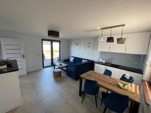 salon ze stołem i niebieską kanapą w obiekcie Apartamenty 5 metrów od morza w Rewie