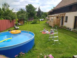 a group of people sitting in a yard next to a pool at Apartment 2 in Hrabušice