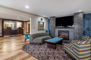 a living room with a fireplace and a tv at Comfort Inn Midtown in Tulsa