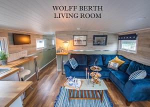 a living room with a blue couch in a tiny house at Barge At Titanic in Belfast