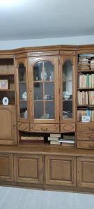een houten kast met glazen deuren en boeken bij Casa M in Câmpulung Moldovenesc