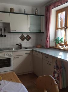 eine Küche mit weißen Schränken und einem Waschbecken in der Unterkunft Ferienwohnung Hörmann in Langdorf