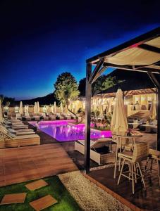 a group of chairs and umbrellas next to a pool at Pensiunea Alexandra & SPA in Divici