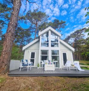 a tiny house with a large window on a deck at Strandhaus Rügen - Sauna, Kamin, Whirlpool in Baabe