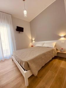 een slaapkamer met een bed en een tv aan de muur bij B&b Quattro Tesori in Canicattì