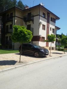 une voiture noire garée devant un bâtiment dans l'établissement Apartman Oaza mira, à Zlatibor
