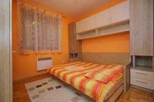 una piccola camera da letto con pareti arancioni e un letto di Apartman Oaza mira a Zlatibor