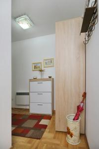 una stanza con cassettiera e scopa in un secchio di Apartman Oaza mira a Zlatibor