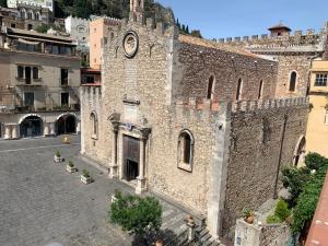 un bâtiment avec une horloge sur son côté dans l'établissement Casa Antica Savoia, à Taormine