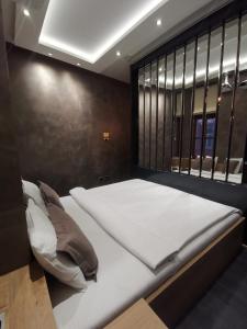 a large bed in a room with a large window at Lux A28 in Novi Sad