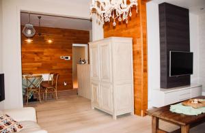 a living room with a television and a white cabinet at De Nachtwaker in Ieper