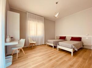 een slaapkamer met 2 bedden en een tafel en stoelen bij B&b Quattro Tesori in Canicattì