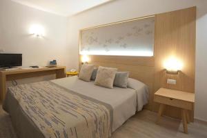 a hotel room with a bed and a television at Costa Dorada in Cala Gonone