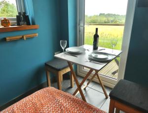 a table with a bottle of wine and two glasses at Little Trenoweth in Saltash