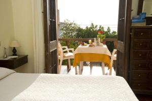 a bedroom with a table and a balcony with a view at Costa Dorada in Cala Gonone