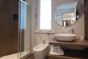 bagno con lavandino e specchio di Hotel La Gradisca a Rimini
