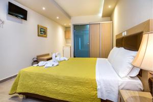 um quarto de hotel com uma cama com toalhas em Hotel Thetis em Limenas