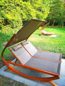 einen Schaukelstuhl auf dem Rasen in einem Park in der Unterkunft Ferienwohnung am Selker Noor in Schleswig