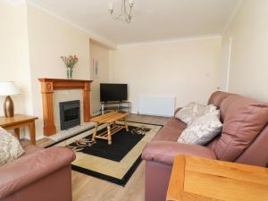 a living room with two couches and a fireplace at 4 Ranby Drive in Hornsea