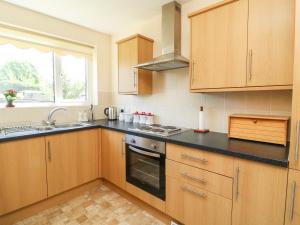 a kitchen with wooden cabinets and a black counter top at 4 Ranby Drive in Hornsea