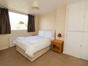 a bedroom with a white bed and a window at 4 Ranby Drive in Hornsea