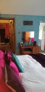 
a bedroom with a bed and a dresser at Penmachno Hall - self catering suite in Betws-y-coed
