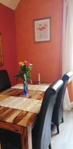 
a dining room table with a vase of flowers on it at Penmachno Hall - self catering suite in Betws-y-coed
