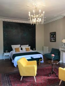 a bedroom with a bed and a chandelier at L'Arche de Moissac in Moissac