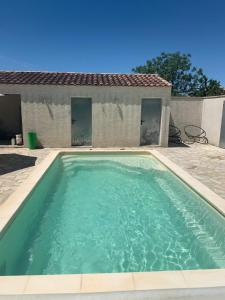 a swimming pool in front of a house at MAS FATINOU in Aniane