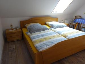 um quarto com uma cama de madeira e 2 almofadas em FeWo Elke em Esens