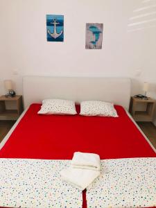 a red bed in a room with two pillows at Lavanda Centar Vir in Vir