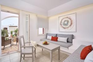 a living room with a couch and a table at Stelia Mare Boutique Hotel in Naousa