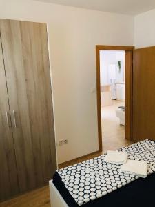 a bedroom with a bed and a door to a bathroom at Lavanda Centar Vir in Vir