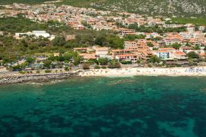 an aerial view of a beach with people in the water at Costa Dorada in Cala Gonone