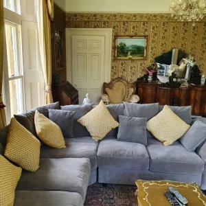 a living room with a blue couch with yellow pillows at Historic Manor House - Sleeps 16 - Pool & Hot Tub in Rochester +48 photos